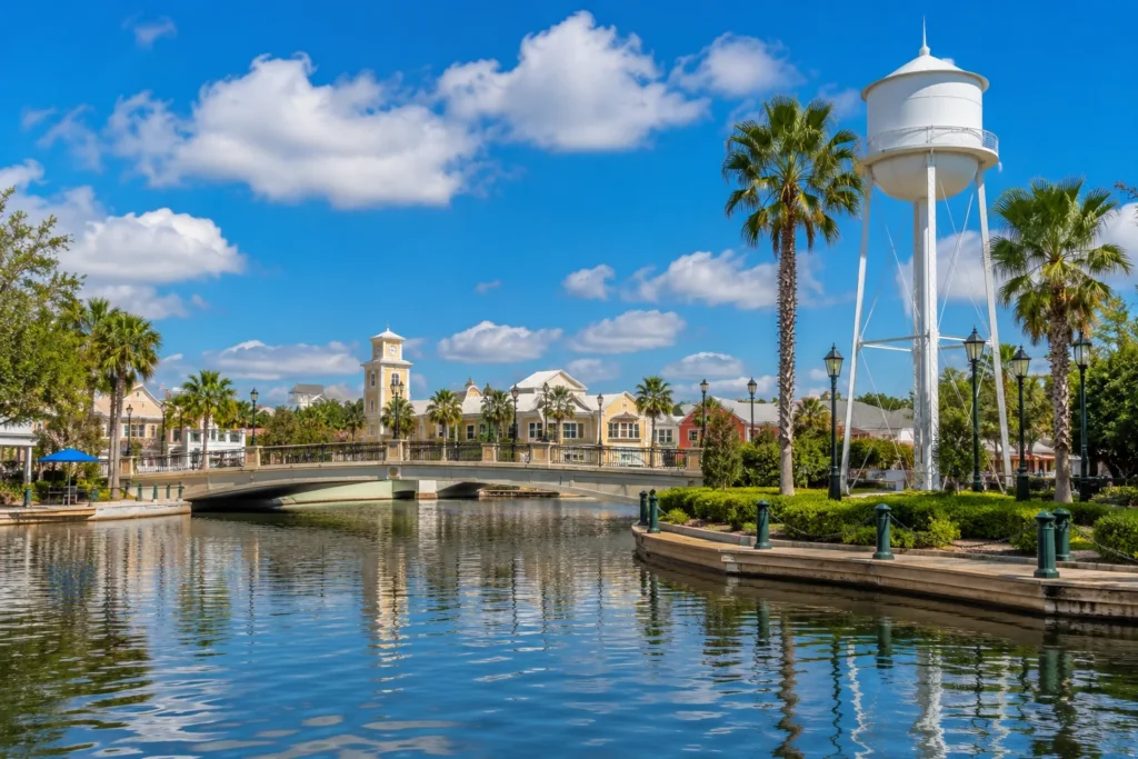 Lakeside promenade with a footbridge, palm trees and a water tower in Celebration, FL