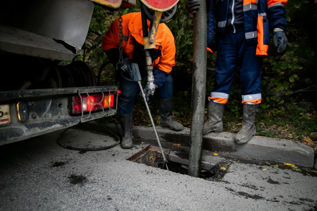 Crew working at an open sewer access in a street
