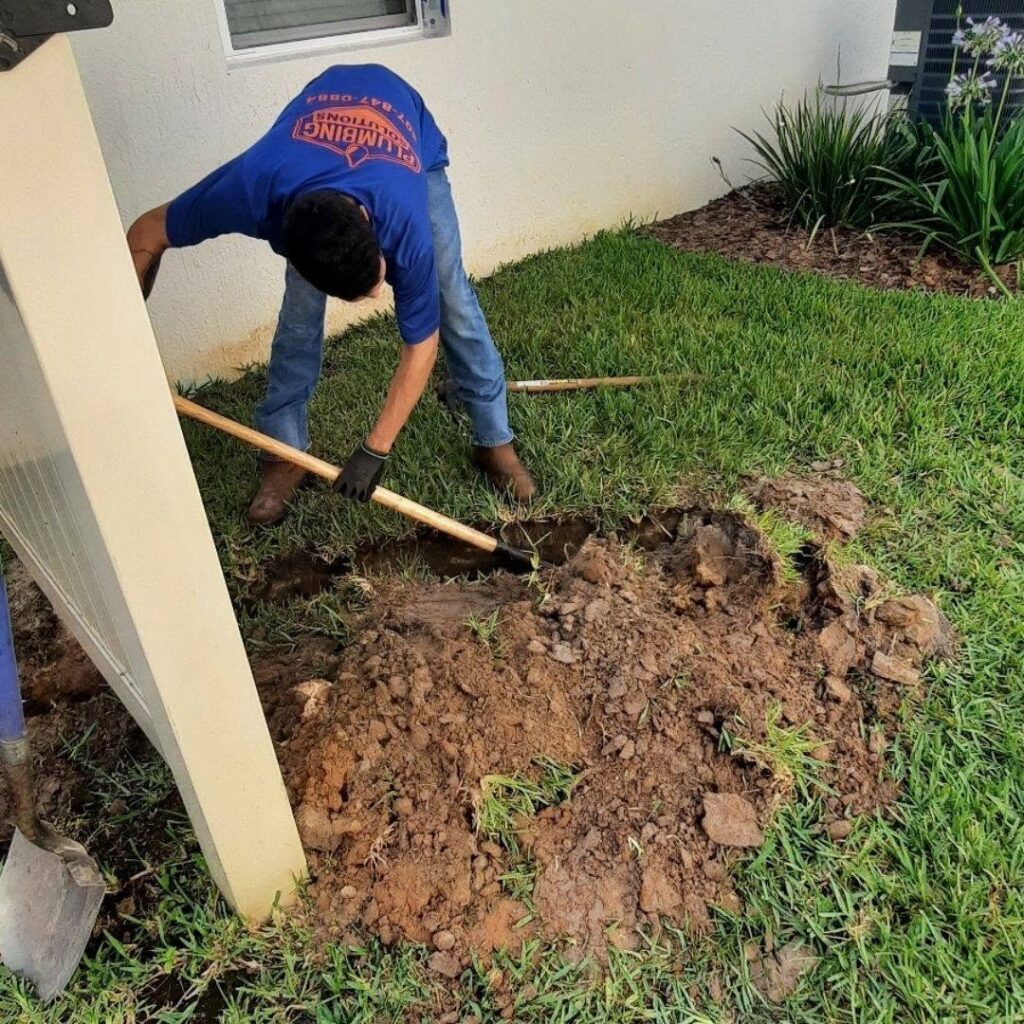 Plumber digging to expose a buried water line