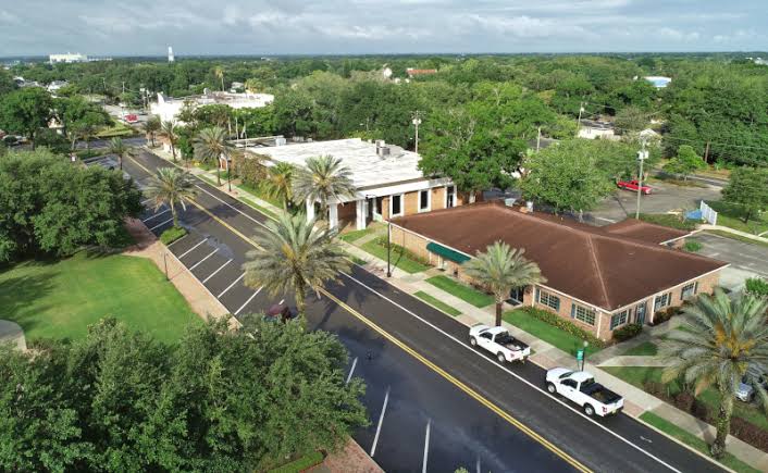 Aerial view of a palm-lined street and buildings in Auburndale, FL