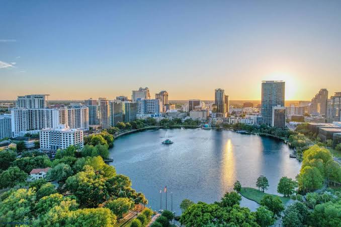 Aerial view of a lake and city skyline at sunset