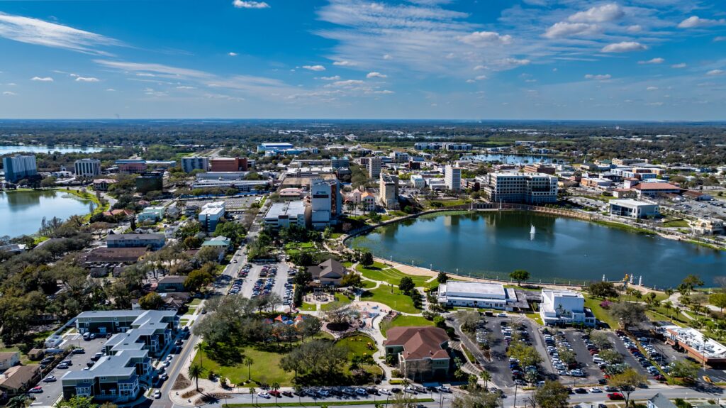 Aerial view of Lakeland, FL, with a lake and downtown buildings